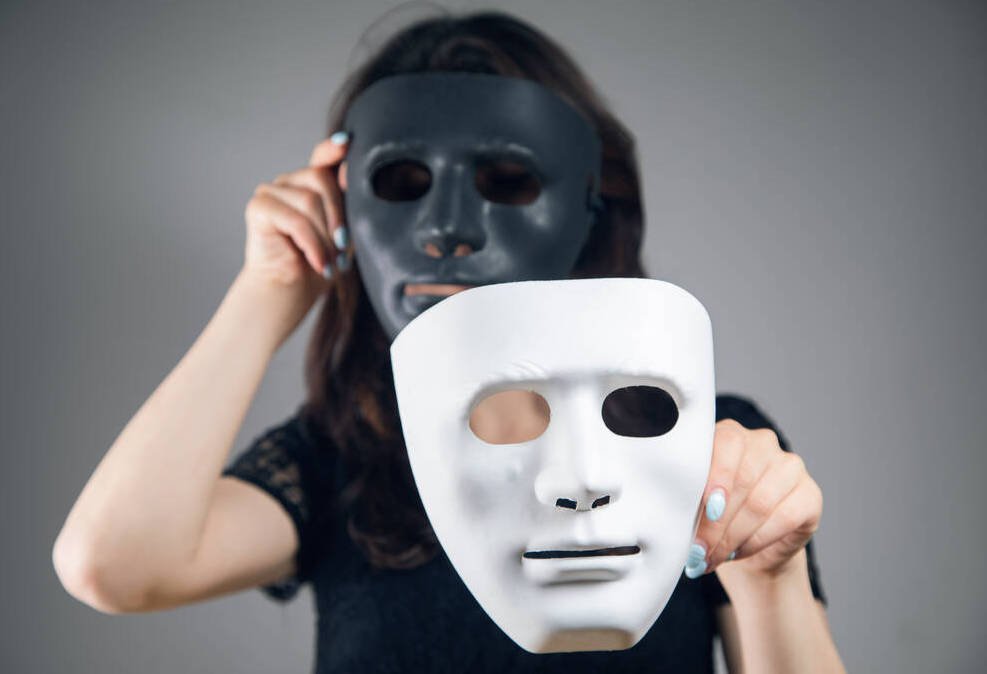 Person holding black and white masks