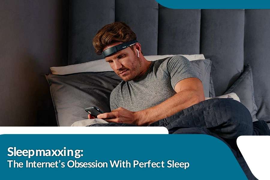 Man using a sleep tracking device and smartphone in bed